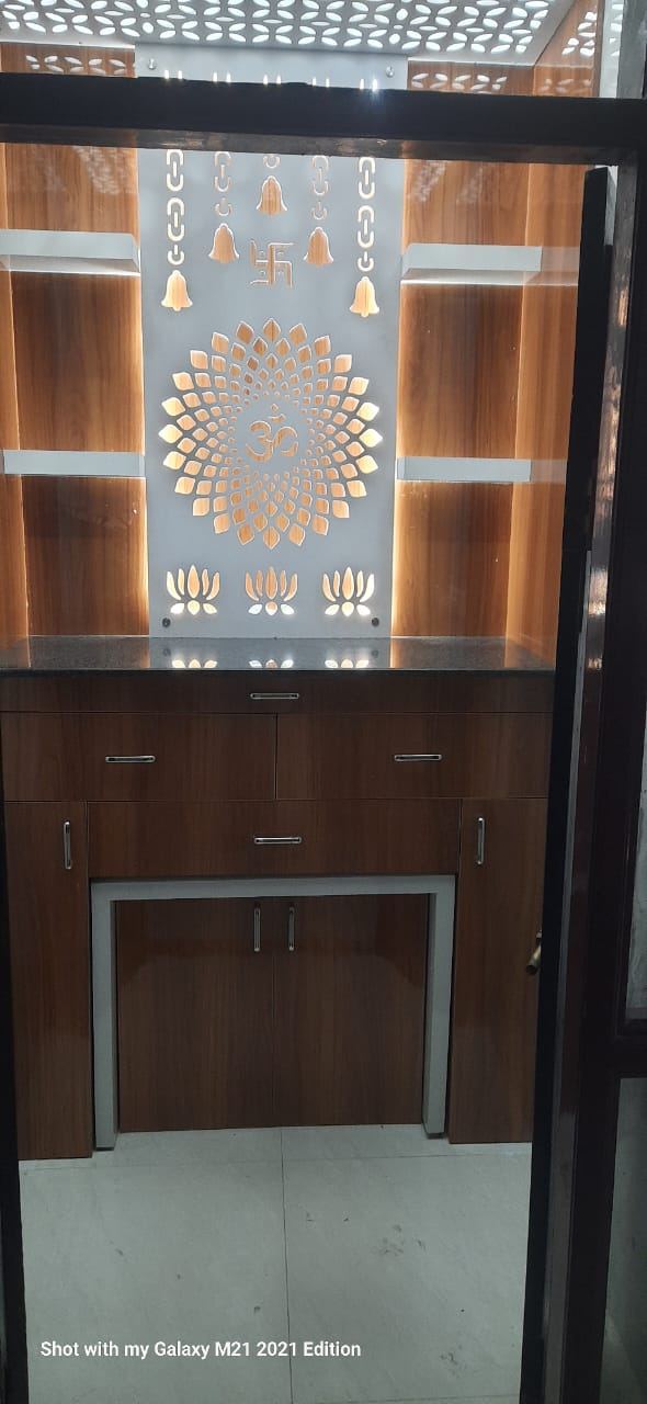 Pooja unit with a backlit cut-out panel, granite platform and walnut shelves