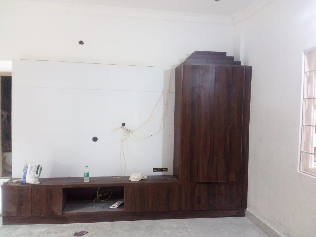 Media wall part-installed with the panel hung and wiring still loose