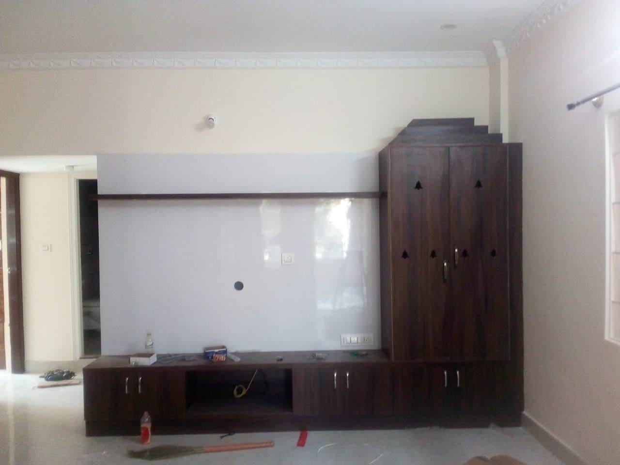Living room media wall with a white lacquered panel and walnut cabinet, lighting not yet connected