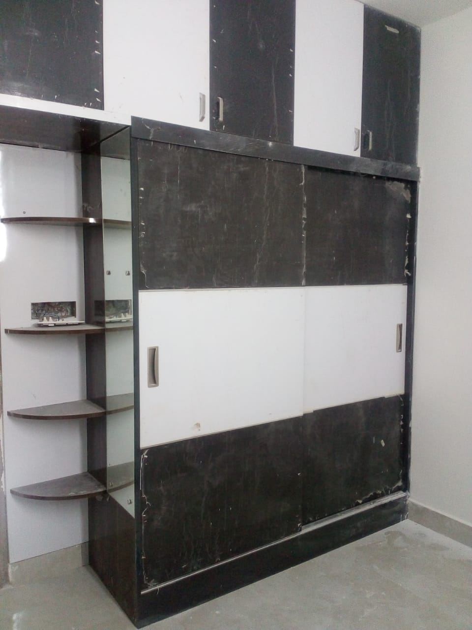 Black and white gloss sliding wardrobe with open corner shelving, protective film still on