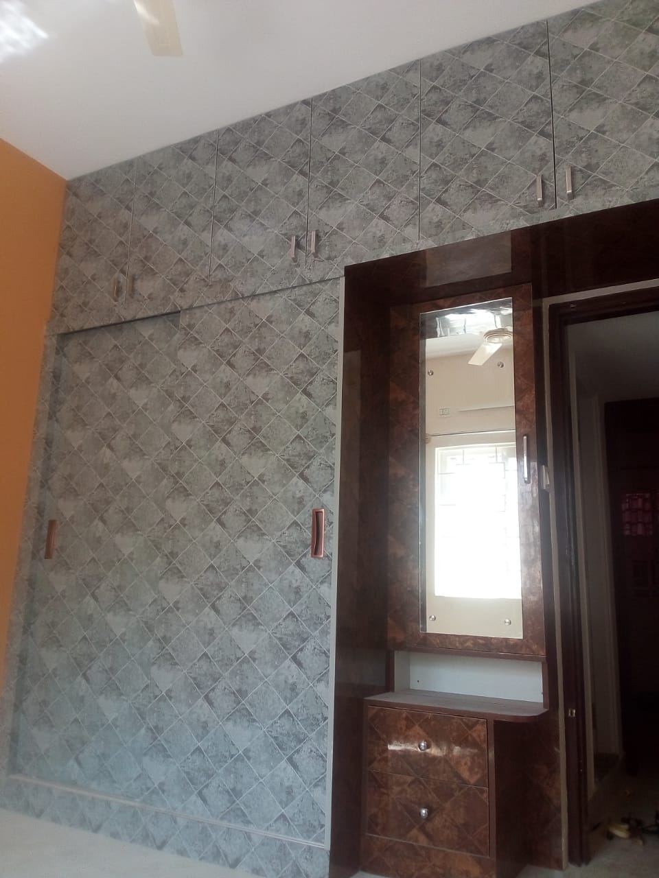 Grey textured laminate wardrobe with an integrated burl-finish dresser and mirror