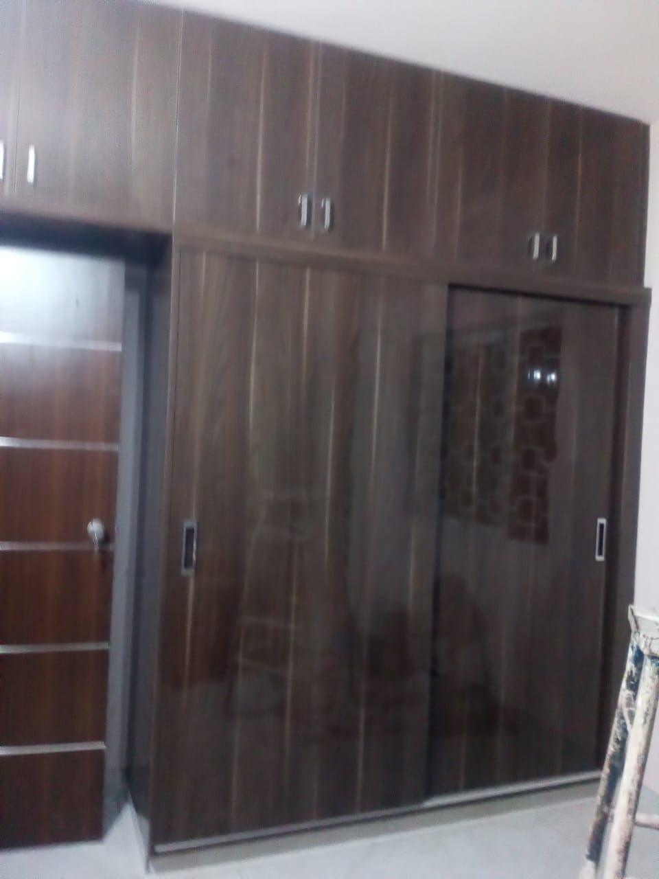 Dark walnut sliding wardrobe with loft units and a mirrored shutter